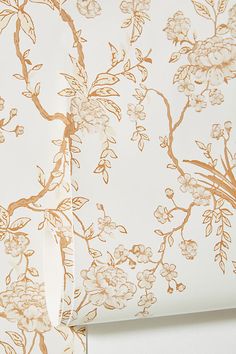 the wallpaper is white and has gold flowers on it, along with an orange stripe