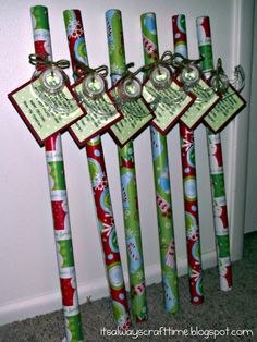 four christmas themed toothbrushes with tags attached to them, all decorated in green and red