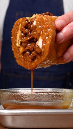 a person dipping some food into a bowl