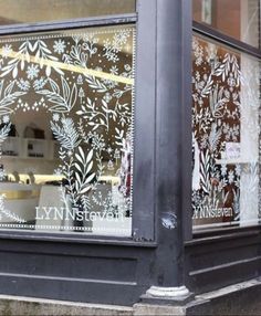 a store front window with decorative glass on it's windowsill and the words lynn street written in gold