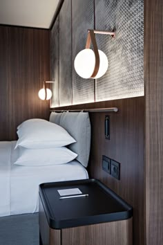 a hotel room with a bed, night stand and bedside table next to the bed