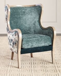 a blue chair sitting on top of a carpeted floor next to a white wall