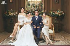 three women and one man are posing for a photo in front of a decorated room