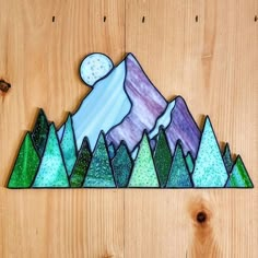 a stained glass mountain scene on a wooden surface