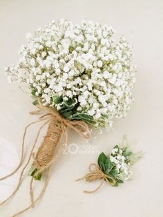 a bouquet of baby's breath tied with twine and burlap on a white surface