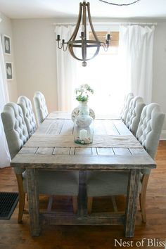 the dining room table is made out of wood and has tufted upholstered chairs