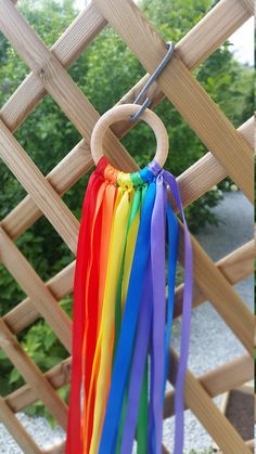 a rainbow wind chime hanging from a wooden trellis