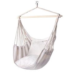 a white hammock chair hanging from a wooden hanger