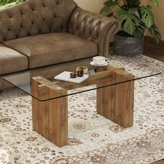 a glass table sitting on top of a rug in front of a couch and chair