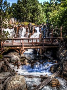 a wooden bridge over a small waterfall