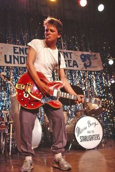 a young man is playing an electric guitar