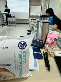 a bag of food sitting on top of a table next to a cup and pen