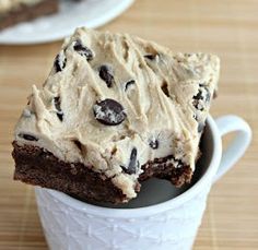 two white plates topped with brownies covered in frosting and oreo cookie dough