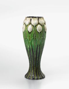 a green vase with white flowers on it