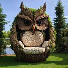 an owl statue sitting on top of a chair in the grass