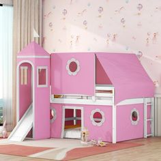 a pink children's bed with a slide in the middle and a play house on top