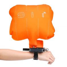 an orange pillow is held up by a person's arm and it has the shape of a bear on it