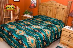 a bed room with a neatly made bed next to a dresser and lamp on top of it