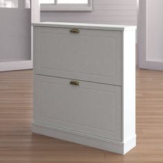 a white cabinet sitting on top of a hard wood floor in front of a window