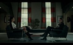 two women sitting in chairs talking to each other