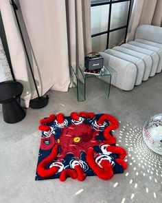 a living room with an octopus rug on the floor next to a chair and table