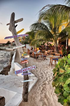 there are many signs on the beach pointing to different destinations and places that you can see