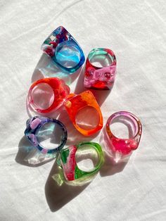 several different colored glasses sitting on top of a white sheet