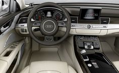 the interior of an audi car with dashboard, steering wheel and electronic display screen in front of cityscape