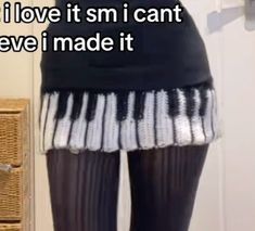 there is a woman wearing tights with white and black stripes on the bottom of her skirt