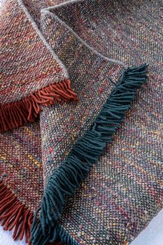 a close up of a blanket with fringes on the bottom and one in the middle