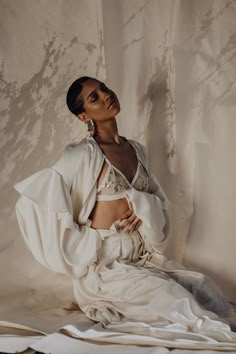 a woman sitting on top of a white sheet