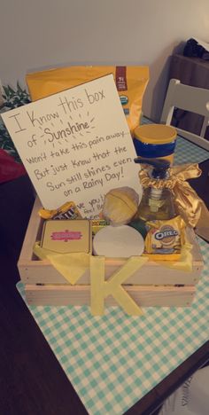 a wooden box filled with cheese and other items sitting on top of a checkered table cloth