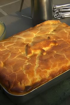 a large baked dish sitting on top of a table next to silverware and utensils