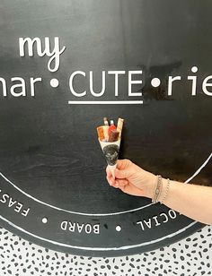 a hand holding a small piece of food in front of a sign that says my smart cute friend