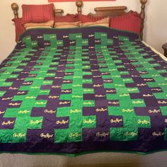 a bed with a green and purple quilt on it