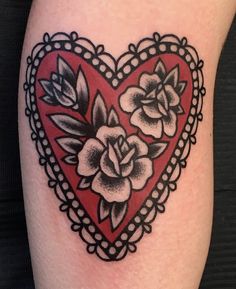 a heart shaped tattoo with flowers on it