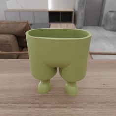 a green cup sitting on top of a wooden table