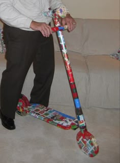 a man standing next to a scooter made out of wrapping paper on the floor