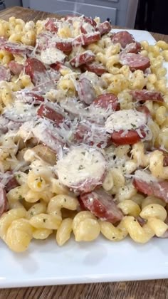 a white plate topped with pasta covered in cheese and meats on top of it