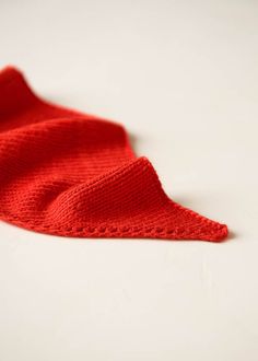 a red knitted cloth laying on top of a white table