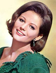 an old photo of a woman smiling at the camera with her hair in a bun