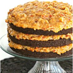 a layered chocolate cake with caramel toppings on a glass plate, ready to be eaten