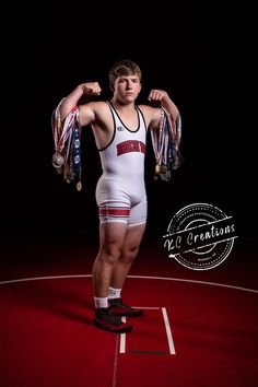 a male wrestler in a white and red wrestling suit with his hands on his hips