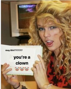 a woman holding up a sign that says you're a clown