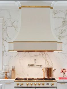 a stove top oven sitting inside of a kitchen next to a wall mounted range hood