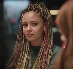 a woman with long blonde dreadlocks looking at her reflection in the mirror and smiling