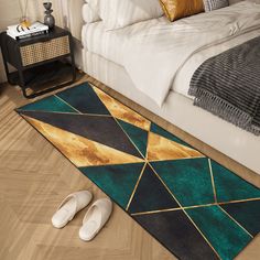 a pair of slippers sitting on the floor in front of a bed with an area rug