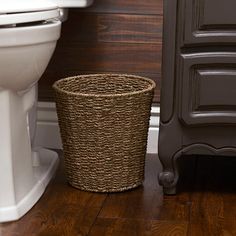 a basket next to a toilet in a bathroom