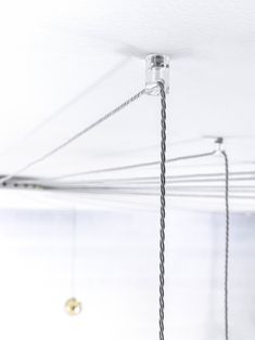 there are several wires attached to the ceiling in this room with white walls and flooring