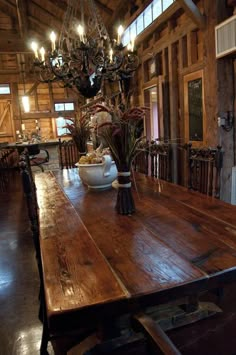 a large wooden dining table in a rustic log cabin with chandelier hanging from the ceiling